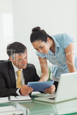 Man and woman working together on a digital tablet