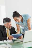 Man and woman working together on a digital tablet