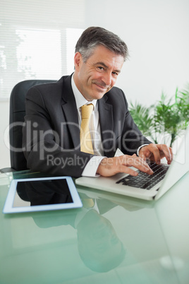 Smiling business man working on laptop