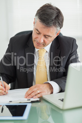 Business man writing on a notepad