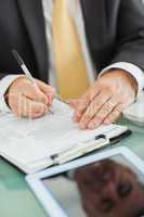 Man writing on a notepad in his office