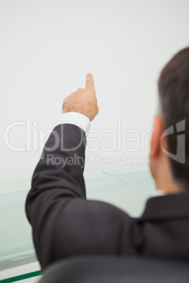 Businessman pointing to a white wall