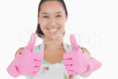 Smiling woman with gloves giving thumbs up