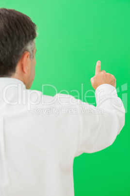 Businessman pointing to chroma key