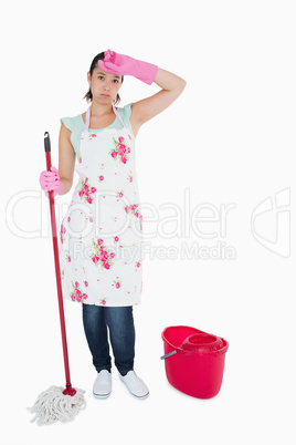 Discouraged woman cleaning floor
