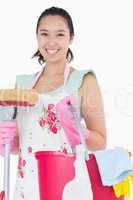 Happy woman holding different cleaning tools