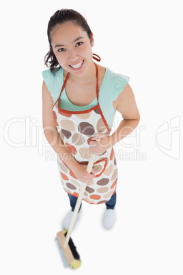 Smiling woman sweeping the floor