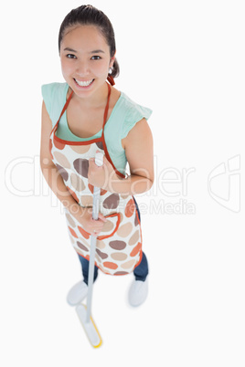 Happy woman sweeping the floor