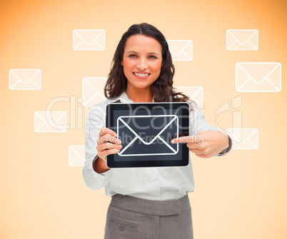 Woman standing smiling while holding a tablet pc and pointing to