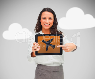 Businesswoman pointing at plane symbol on tablet pc