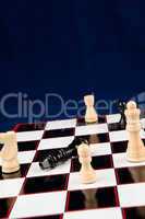 Black queen lying at the chessboard