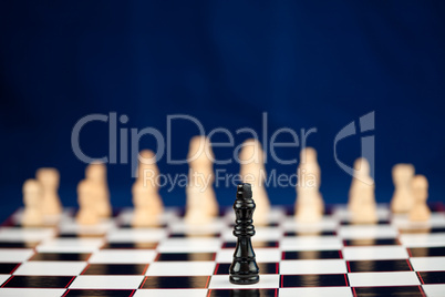 Black chess piece standing at the chessboard