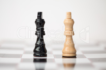 Chess pieces standing at the chessboard beside each other