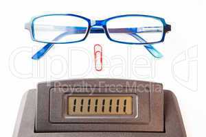 Sector of calculator display with glasses and paper clip