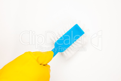 Hand in rubber glove using scrubbing brush