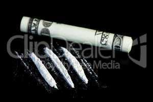 Lines of illegal substance next to rolled up dollar bill