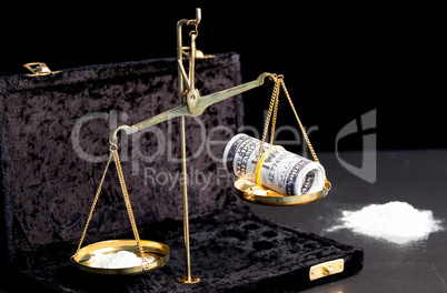 Weighing scales with dollars and drugs