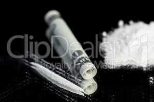 Pile of white substance beside rolled up note and line