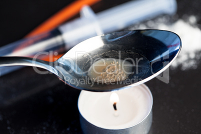 Heroin being cooked in a spoon over a candle