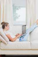 Woman typing on the laptop while relaxing