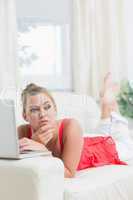 Woman looking thoughtful while using notebook