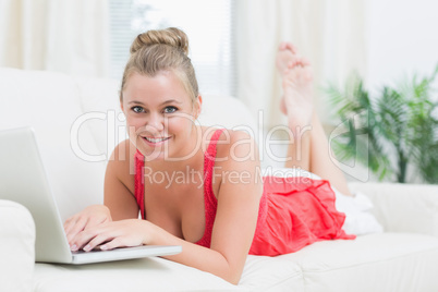 Blonde smiling while relaxing and using the notebook Blonde smiling while relaxing and using the notebook