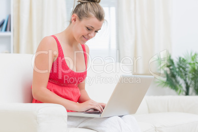 Woman typing on notebook while relaxing