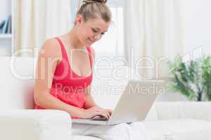 Woman typing on notebook while relaxing