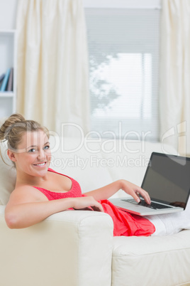 Woman typing on laptop and smiling