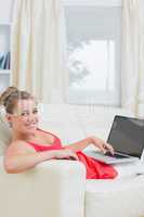 Woman typing on laptop and smiling