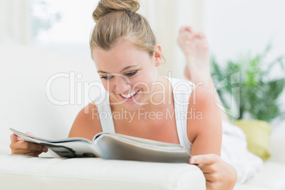 Woman smiling and reading a magazine