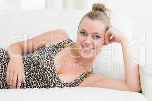 Woman smiling while lying on sofa