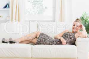 Woman smiling and lying on sofa
