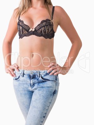 Woman in jeans and bra posing