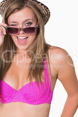 Woman holding her glasses while winking
