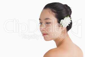 Woman wearing a flower in hair and looking away