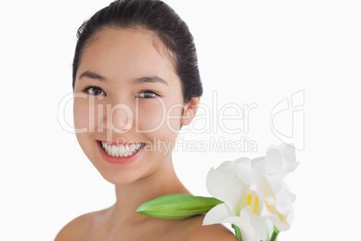 Joyful woman having a flower on her shoulder