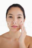 Black haired woman touching her face