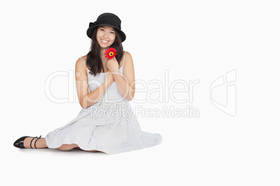 Woman with flower in dress sitting on floor