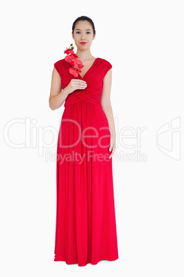 Woman in red evening gown with orchids