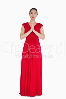 Woman in red dress with hands together