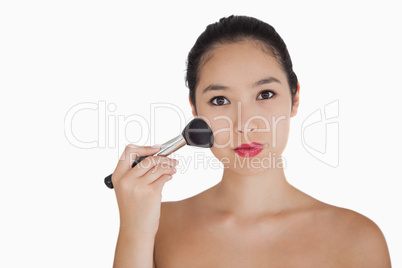 Woman holding a brush to her face
