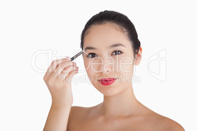 Smiling woman filling in eyebrows