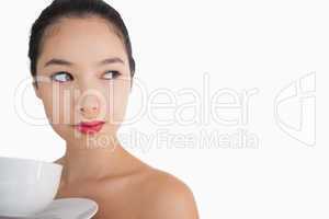 Woman holding a cup of coffee looking away