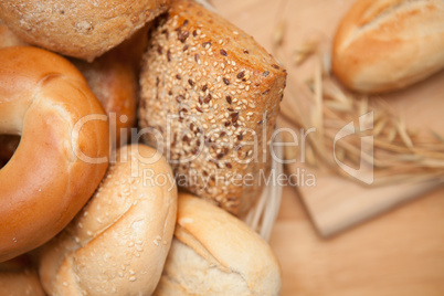 Bread in the basket with a roll on a wooden board