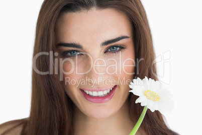 Brunette holding a flower and smiling