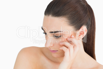 Woman touching her face while looking down