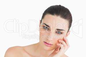 Pale looking woman touching her face