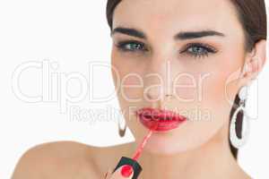 Woman applying red lip gloss