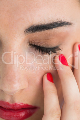 Woman with red lips touching her skin